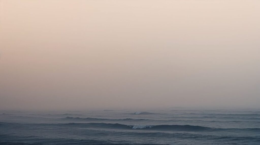 Foggy coastal landscape wallpaper with misty ocean waves